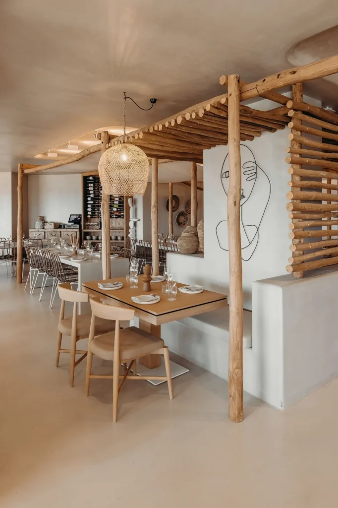 Interno di ristorante moderno con travi in legno, arredi minimalisti, lampadario intrecciato e decorazione murale con arte lineare