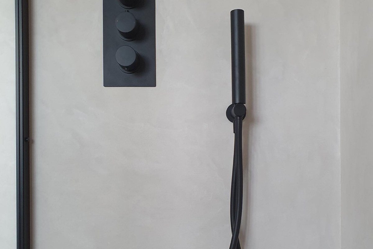 Roman Cement shower wall with black fixtures